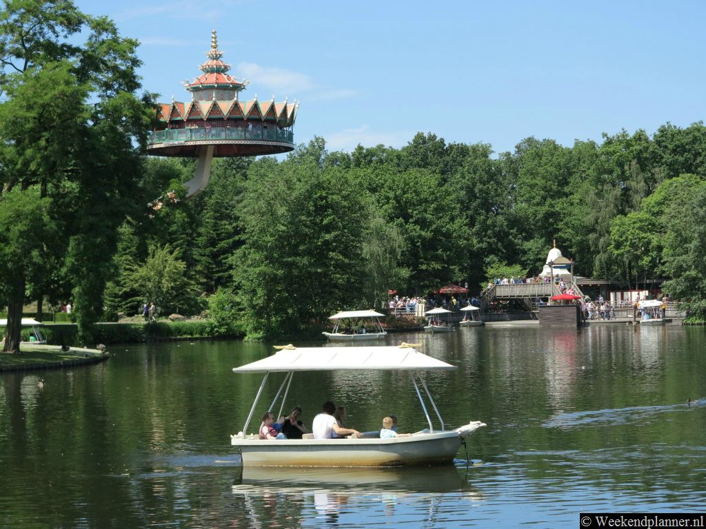 In de grote vijver varen bootjes een vaste route. Op de achtergrond zie je de Pagode. In de Pagode wordt je hoog boven de grond getild en heb je een mooi uitzicht op het themapark.